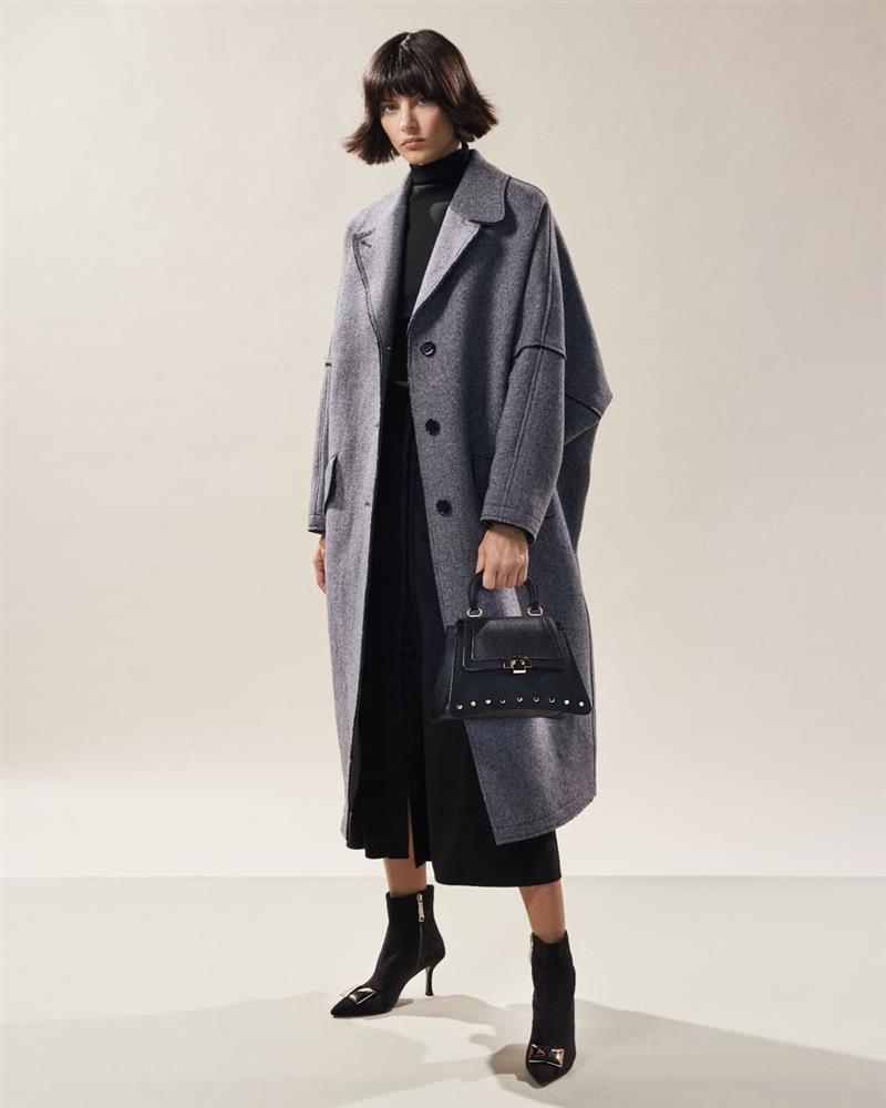 femeie imbracata in negru cu palton gri